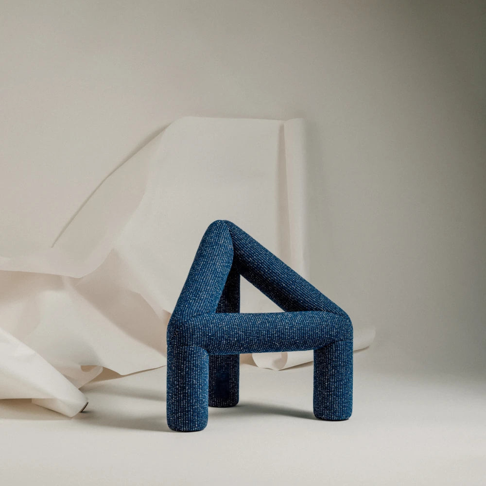 Closer view of the blue A Chair by Garnier Pingree, highlighting its woven upholstery, rounded joints and three substantial legs.